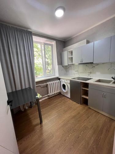 a small kitchen with white cabinets and a window at New stail centru in Bălţi