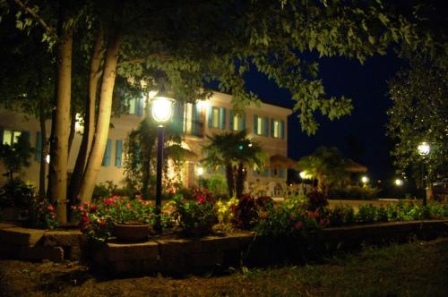 una casa con una luz de la calle y flores por la noche en Agriturismo Dolceacqua, en Cavallino-Treporti