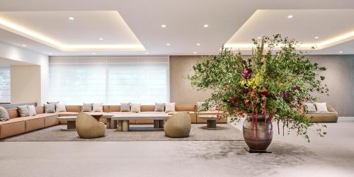 - un hall avec un canapé et un vase de fleurs dans l'établissement Hotel Flora Funabashi, à Funabashi