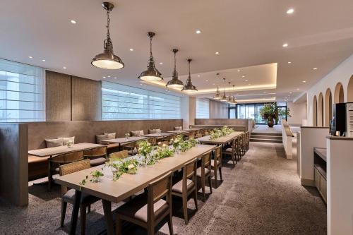 une salle à manger avec de longues tables et chaises dans l'établissement Hotel Flora Funabashi, à Funabashi