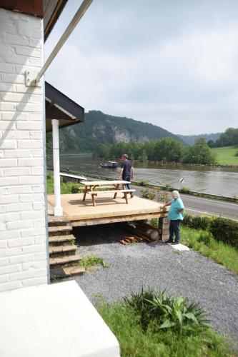 twee mannen die werken op een houten dek naast een rivier bij Le Paradis Mosan in Waulsort