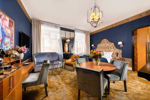 uma sala de estar com uma cama, uma mesa e cadeiras em Balthazar Design Hotel na Cracóvia