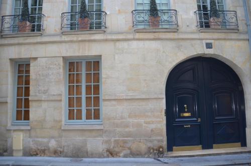 a building with a black door and windows at La Maison d'Anne in Paris