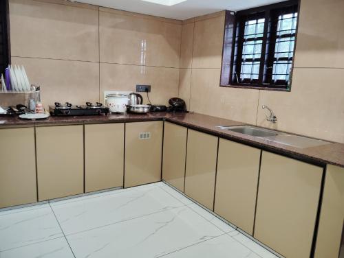 una cucina con lavandino e piano di lavoro di MATHER RAJAGIRI FURNISHED APARTMENTS ad Alwaye