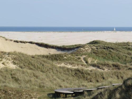 een picknicktafel op een strand met de oceaan op de achtergrond bij Heckenrose-6-Souterrain-links in Norddorf