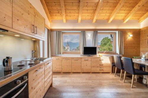 eine Küche mit Holzschränken und einem großen Fenster in der Unterkunft Apartment Sassun in Lajen