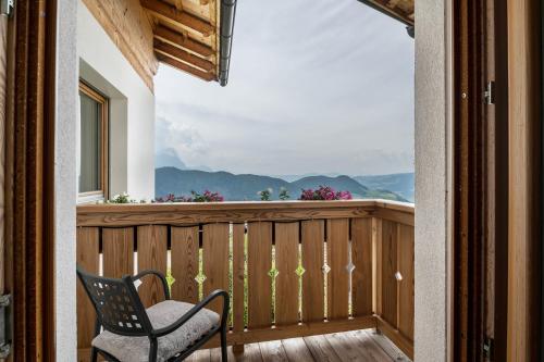 einen Stuhl auf einem Balkon mit Bergblick in der Unterkunft Apartment Sassun in Lajen