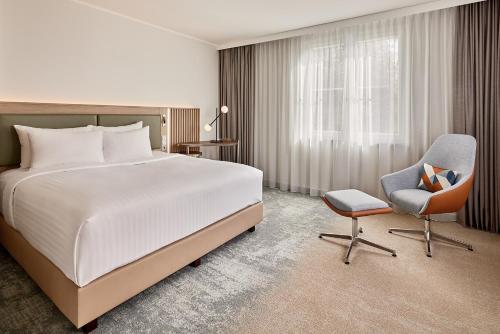 une chambre d'hôtel avec un lit et une chaise dans l'établissement Courtyard by Marriott Dortmund, à Dortmund