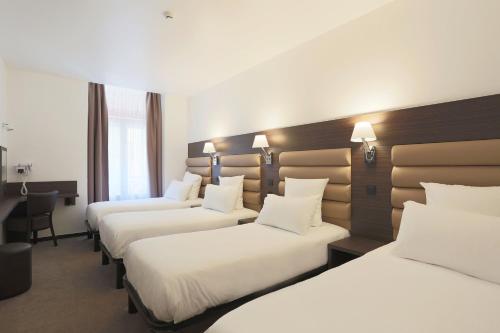 a row of beds in a hotel room at Hôtel & Appartements Monsigny in Nice