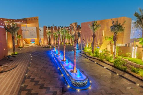 Una fila de palmeras en una calle por la noche en Vivienda Hotel and Villas, Diplomatic Quarter, en Riad