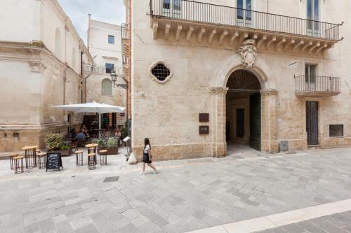 uma mulher a andar em frente a um edifício em Palazzo Zimara Boutique Hotel em Lecce