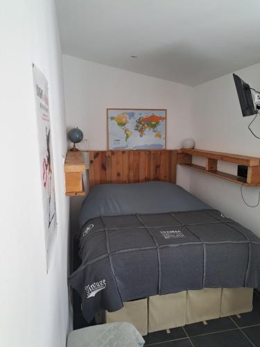 ein Schlafzimmer mit einem Bett und einer Karte an der Wand in der Unterkunft petit studio indépendant dans jardin avec parking et portail électrique in Marseille