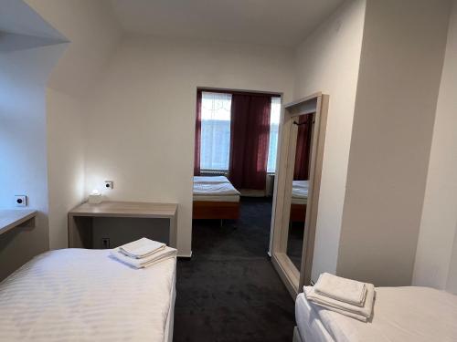 um pequeno quarto com 2 camas e um espelho em Hotel Praha Liberec em Liberec