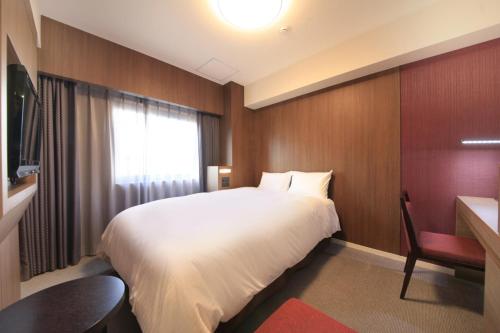 Richmond Hotel Kagoshima Kinseicho tesisinde bir odada yatak veya yataklar