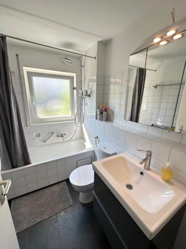 a bathroom with a sink and a toilet and a mirror at Double Bed Apartment - Near Marienplatz in Stuttgart