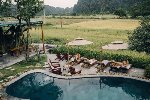 a group of people sitting in chairs by a pool at Tam Coc Windy Fields in Ninh Binh