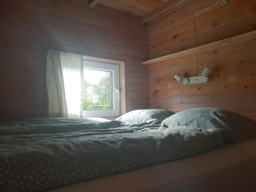 een slaapkamer met een bed voor een raam bij Hytte C in Gråsten