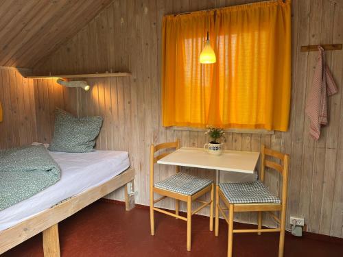 a small room with a bed and a table and chairs at Hytte A in Gråsten