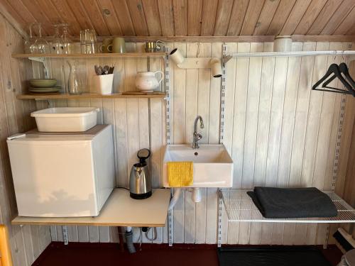 a small kitchen with a sink and a refrigerator at Hytte A in Gråsten