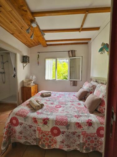 - une chambre dotée d'un grand lit avec un couvre-lit floral dans l'établissement la souquette, à Draguignan