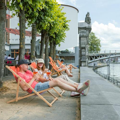 un gruppo di persone seduti su sedie a sdraio in riva al mare di Penthouse GuiZa a Namur