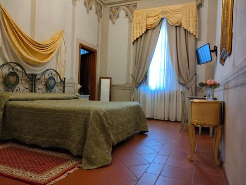 een slaapkamer met een bed en een raam met gordijnen bij Hotel Villa Cheli in Lucca