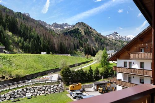 un balcone con vista sulle montagne di un edificio di Appartamento Cesa Portados Gabi 2 a Livinallongo del Col di Lana