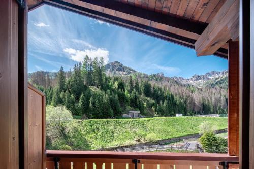 una finestra con vista sulle montagne da una casa di Appartamento Cesa Portados Gabi 2 a Livinallongo del Col di Lana