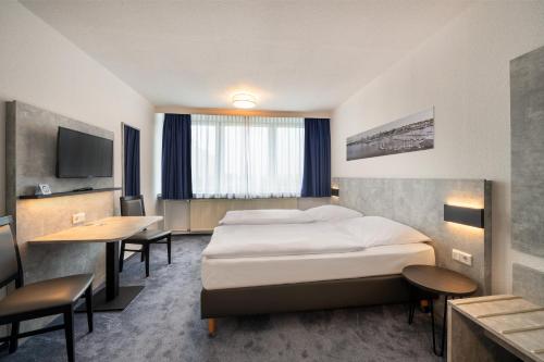 een hotelkamer met een bed en een bureau bij Hotel & Gästehaus Rostock Lütten Klein in Rostock