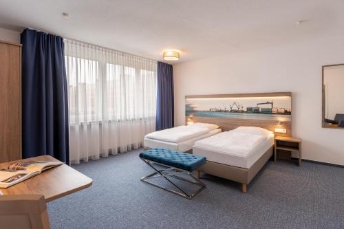 een hotelkamer met 2 bedden en een tafel bij Hotel & Gästehaus Rostock Lütten Klein in Rostock