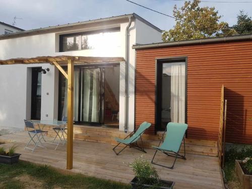 een patio met stoelen en een tafel en een huis bij Notre petite maison in La Rochelle