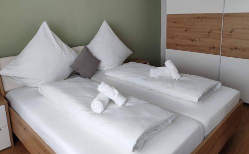 Una cama blanca con almohadas y toallas. en Apartment Marissa, en Billerbeck