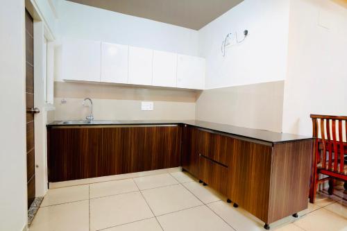 una cucina con armadi in legno e lavandino di Elite Enclave - Mysore - 2BHK Luxury Serviced Apartments a Mysore