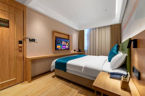 um quarto de hotel com uma cama e uma televisão em 锦泰酒店-广州市南方大厦国际电子城一德路地铁站店 em Guangzhou