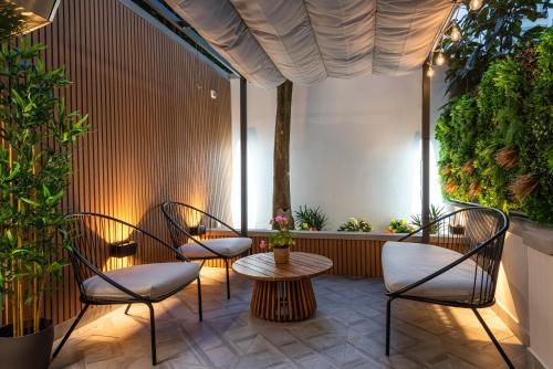 patio con sedie, tavolo e alcune piante di Elegante Appartamento con Giardino Privato, Jacuzzi nel Cuore di Firenze a Firenze