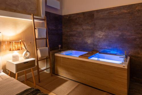 un bagno con vasca blu in una camera da letto di Elegante Appartamento con Giardino Privato, Jacuzzi nel Cuore di Firenze a Firenze