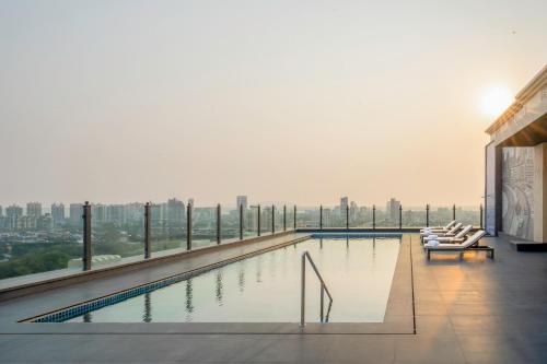 una piscina all'ultimo piano di un edificio di Navi Mumbai Marriott a Navi Mumbai