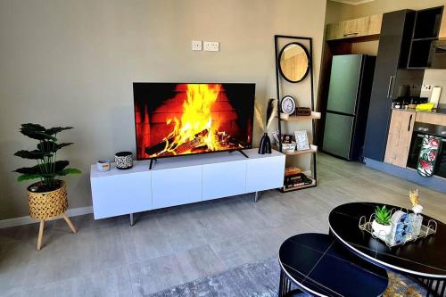 uma sala de estar com lareira numa televisão em Cozy 1-Bed Apartment in Gaborone em Gaborone