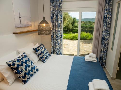 a bedroom with a bed with blue and white pillows at Kotroni Villas in Finikounta