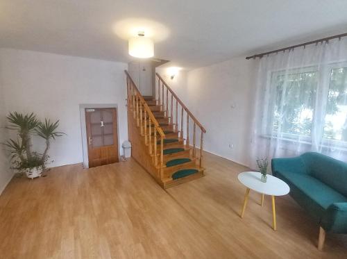 a living room with a blue couch and a staircase at KRK stop in Cholerzyn