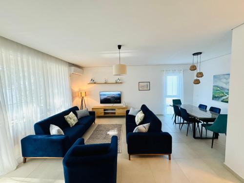 een woonkamer met blauwe banken en een eetkamer bij M&E Premium Apartments - San Pietro in Durrës