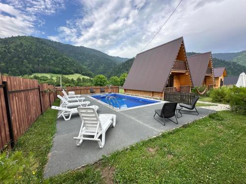 un patio trasero con una piscina con sillas y una casa en Eco House Borjomi, en Borjomi