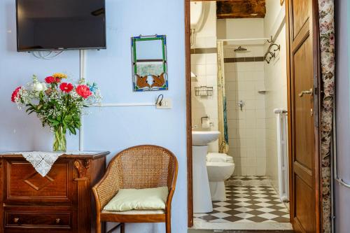 bagno con servizi igienici e vaso di fiori di Antica Casa Dei Rassicurati a Montecarlo