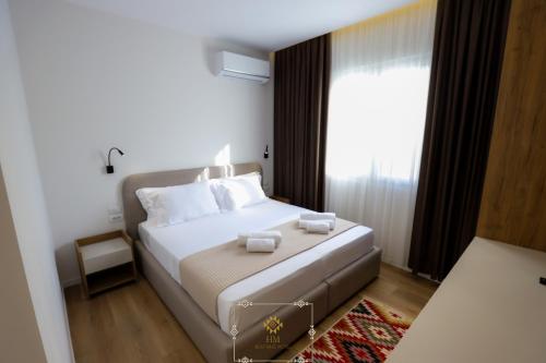 a bedroom with a bed with two towels on it at HM Boutique Hotel in Krujë