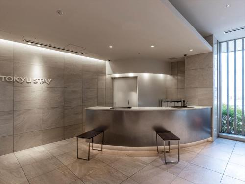 a lobby with two chairs and a counter in a building at Tokyu Stay Shimbashi - Ginza area in Tokyo