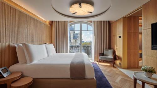 um quarto com uma grande cama branca e uma janela em Hotel Lutetia em Paris