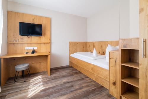 a hotel room with a bed and a tv at Hotel & Gasthof Richard Held in Regensburg