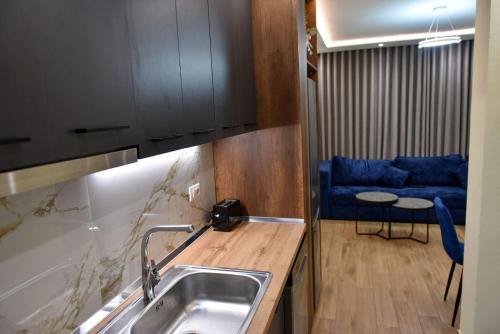 a kitchen with a sink and a blue couch at Vila Noar in Vlorë