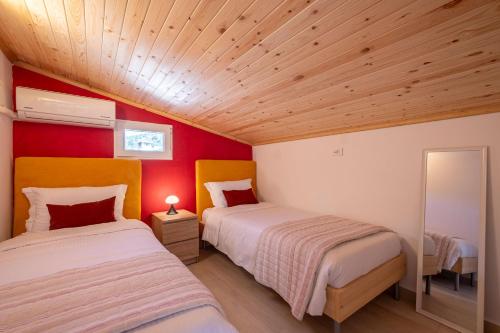 Cet hébergement comprend 2 lits dans une chambre dotée de murs rouges et de plafonds en bois. dans l'établissement Tolo Villa Natura with Pool for 8 - private, luxury accommodation, à Tolón