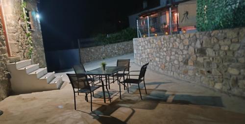 a table and chairs on a patio at night at Vaki's country house in Pylos